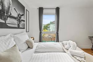 Una cama blanca en una habitación con ventana. en NobleNest Deluxe - Massage - Kaffee - Arbeitsplatz, en Viena