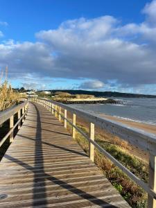a wooden boardwalk leading to the ocean on a beach at Apartamento Tronqueiras in Praia da Vitória