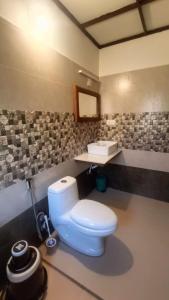a bathroom with a white toilet and a sink at Heritage Farm Kerala in Idukki +37 photos