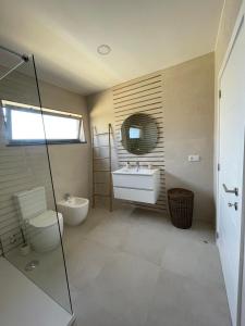 a bathroom with a sink and a toilet and a mirror at Apartamento Tronqueiras in Praia da Vitória +42 photos