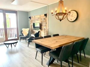 a dining room with a table and chairs and a clock at Kappeberg Lodge in Winterberg