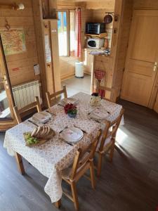 a table in a cabin with a table cloth on it at La Marmotte in Chorges +6 photos
