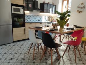 una cucina con tavolo e sedie in legno di CoLiving des Moulins sur Crémieu 3étoiles - Proche de Lyon & Bugey a Crémieu Altre 53 foto