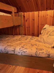 a bed in a room with wooden walls at La Marmotte in Chorges +6 photos
