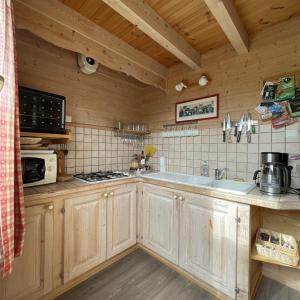 a kitchen with wooden cabinets and a stove top oven at La Marmotte in Chorges