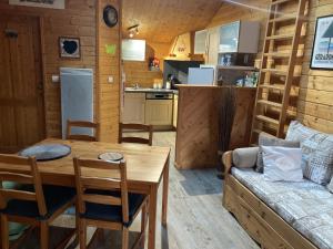 a kitchen and living room with a table and a couch at Chalet au coeur du vieux Gérardmer in Gérardmer