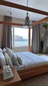 a bedroom with a bed with a view of the ocean at Otium 1 in Qantab +10 photos
