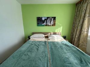 un letto in una camera da letto con parete verde di Urlaub am Fieglerberg a Fiegler