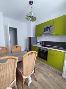 a kitchen with a table and some green cabinets at Haus Christoffel Wieda - Ruhe, Natur & Wandern im Harz in Wieda