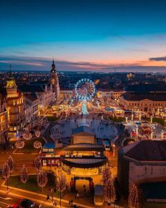 una città illuminata di notte con una ruota panoramica di La Strada Central Apartament a Oradea