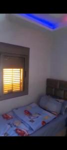 a bedroom with a bed and a window with a blue light at Appartement de luxe in Dakhla +14 photos