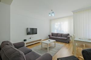 a living room with two couches and a tv at Fethiye Merkezde Lüx Daire in Fethiye