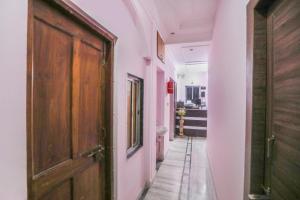 a hallway with a wooden door and a bathroom at Hotel O Ma Kali Guest House in Kolkata
