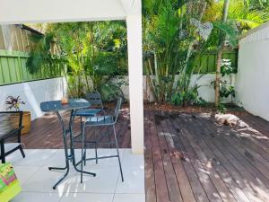 a patio with a table and chairs on a deck at Villa Nini46 in Noumea