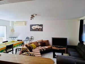 a living room with a couch and a tv at Villa Nini46 in Noumea