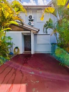 a house with palm trees and a driveway at Villa Nini46 in Noumea