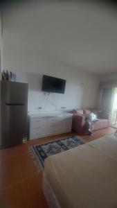 ein Wohnzimmer mit 2 Betten, einem TV und einem Sofa in der Unterkunft Blocco 59 Domina Coral Bay in Sharm El Sheikh