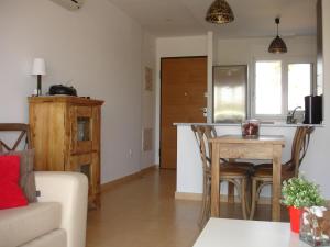 a living room with a kitchen and a table with chairs at Mar Menor Golf Resort Rental in Torre-Pacheco