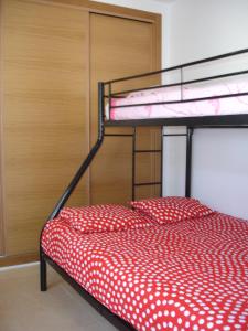 a bunk bed with a red and white polka dot sheets at Mar Menor Golf Resort Rental in Torre-Pacheco