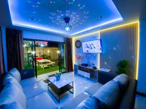 ein Wohnzimmer mit Sofa und Tisch in der Unterkunft Fhamai Pool Villa Pattaya (บ้านฟ้าใหม่ พูลวิลล่า) in Ban Huai Yai