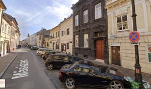 a row of cars parked on a street next to buildings at Masiarska Apartment 1 Best Adress In City Center Kosice in Košice