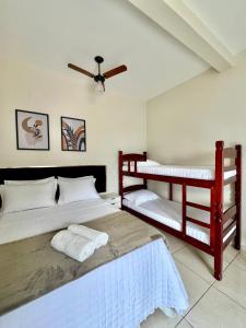 a bedroom with two bunk beds and a ceiling fan at Pousada Aconchego De São Thomé in São Thomé das Letras