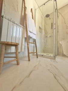 a bathroom with a wooden chair and a shower at Casa da Touça in Arcos de Valdevez +54 photos
