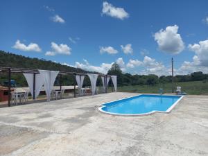 a swimming pool in the middle of a parking lot at Hotel Restaurante e Camping Beija Flor in Capitólio +43 photos