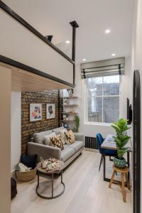 a living room with a couch and a table at Kensington I Your Apartment in London