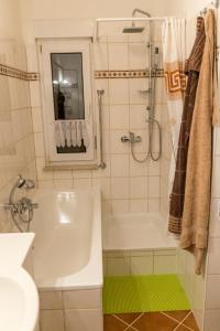 ein Badezimmer mit einer weißen Badewanne und einem Waschbecken in der Unterkunft Ferienwohnung-Schwanke in Wernigerode