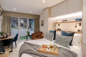 a bedroom with a bed with a tray of food on it at Kensington I Your Apartment in London
