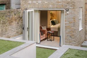 an open door to a room with a bedroom at Kensington I Your Apartment in London