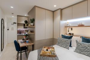 a bedroom with a bed and a table with a tray of food at Kensington I Your Apartment in London