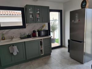 PezensにあるCharmante villa à Pezensのキッチン(緑のキャビネット、冷蔵庫付) +5枚の写真