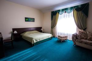 ein Schlafzimmer mit einem Bett, einem Fenster und einem Stuhl in der Unterkunft Hotel Maraphon in Lipezk
