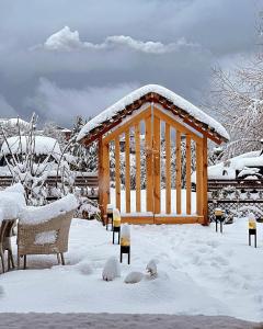 einen hölzernen Pavillon mit Schnee auf dem Boden in der Unterkunft Amarys Boutique Stays Manali in Manali