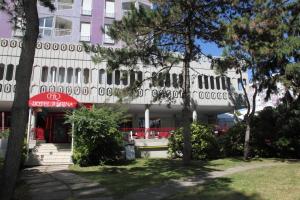 a white building with trees in front of it at Hotel Regina in Lignano Sabbiadoro