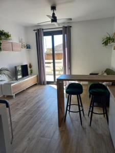 a living room with a wooden table and two stools at Cal Hidalgo in Palouet
