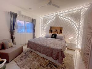a bedroom with a large white bed and a couch at Amenti House - Private Villa & Retreat Center in Luxor