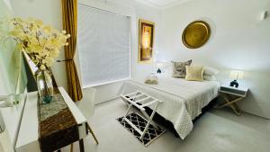 a bedroom with a bed and a vase of flowers at Cosy Family 2-Bedroom Cottage with Braai, Fireplace, Kitchen near Strand Beach in Strand