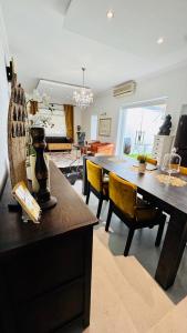 a living room with a dining room table and chairs at Cosy Family 2-Bedroom Cottage with Braai, Fireplace, Kitchen near Strand Beach in Strand