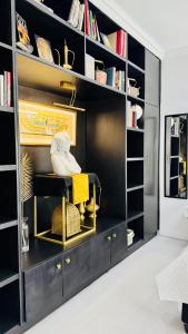 a black book shelf filled with lots of books at Cosy Family 2-Bedroom Cottage with Braai, Fireplace, Kitchen near Strand Beach in Strand