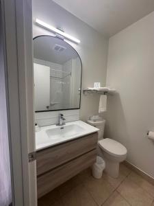a bathroom with a sink and a toilet and a mirror at Motel Blanche d'Haberville in Saint-Jean-Port-Joli +21 photos