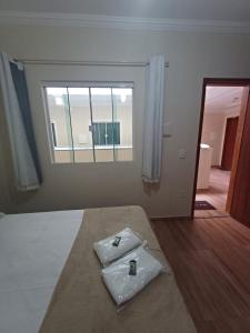 een slaapkamer met een bed, een raam en een spiegel bij Pousada Estrela Mares 304 in Cabo Frio