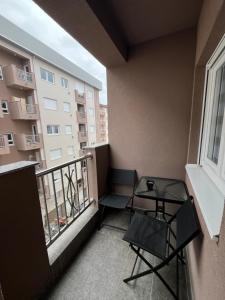 a balcony with a table and chairs on a building at Apartman Avatar in Bijeljina