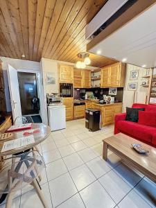 a living room with a red couch and a kitchen at Ladybird Inn in Chamonix-Mont-Blanc +10 photos