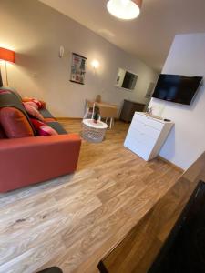 a living room with a couch and a flat screen tv at Chamrousse Residence le Balcon de Recoin - Au pied des pistes in Chamrousse