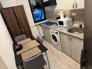 a small kitchen with a table and a microwave at Apartament Ultracentral Modern 1 Pitesti in Piteşti