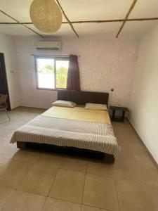 a bedroom with a large bed in a room at Omanye Lodge in Accra +6 photos