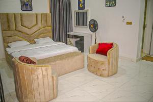 a bedroom with a bed and a chair and a clock at Mclanraysterlin in Lagos Island